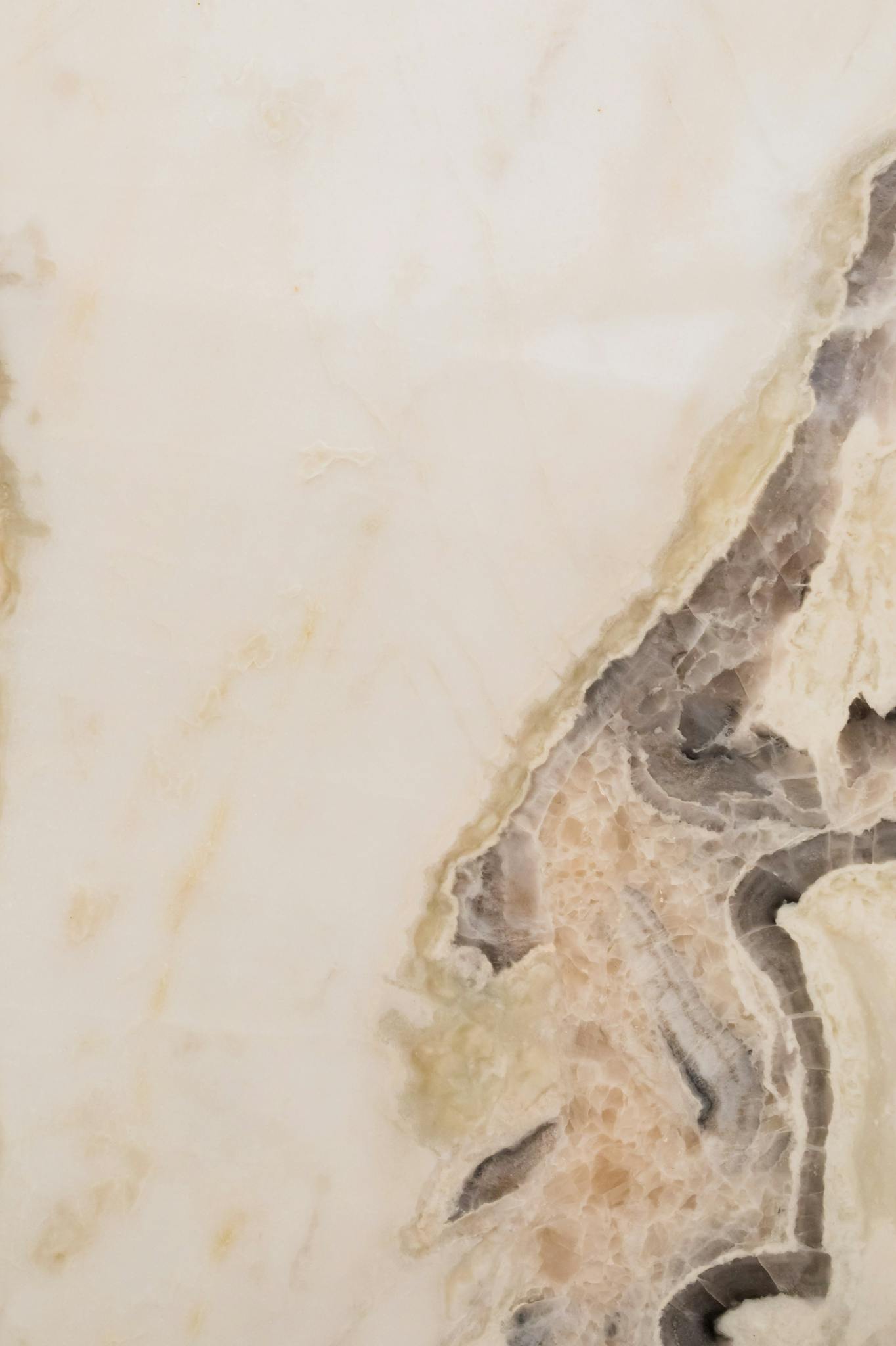 Close-up of a marble stone texture with intricate patterns and neutral tones.